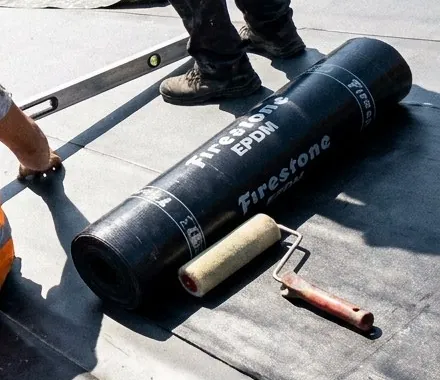 Rouleau de membrane EPDM et rouleau de colle sur un toit plat à Woluwe-Saint-Pierre